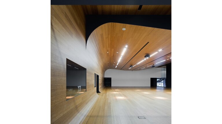 Großer Raum mit fließender Holzverkleidung überall.